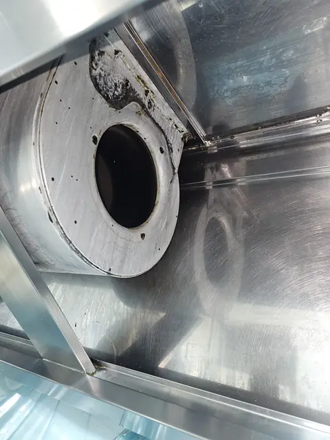Carcasa ventilatorului centrifugal din interiorul hotei, cu depuneri de grăsime pe suportul superior