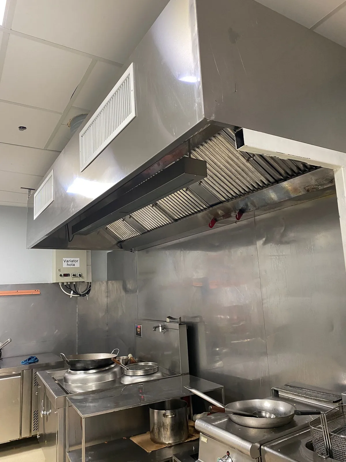Hotă profesională din inox cu filtre labirint, grile de aer proaspăt și variator de turație pe perete
