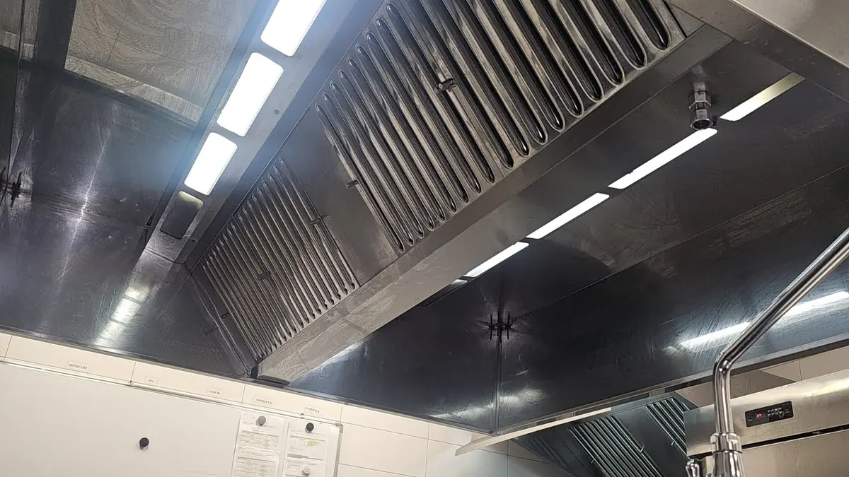 Hotă din inox văzută de dedesubt, cu filtre labirint curate și corpuri de iluminat LED integrate