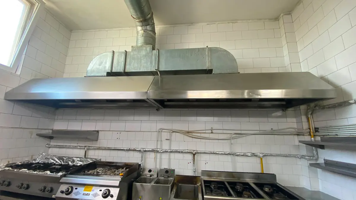 Hotă de perete din inox racordată la tubulatură galvanizată rectangulară și spiralată, deasupra liniei de gătit