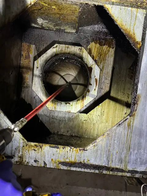 Lance de spălare introdusă în tubulatura de exhaustare prin carcasa ventilatorului încărcată cu grăsime