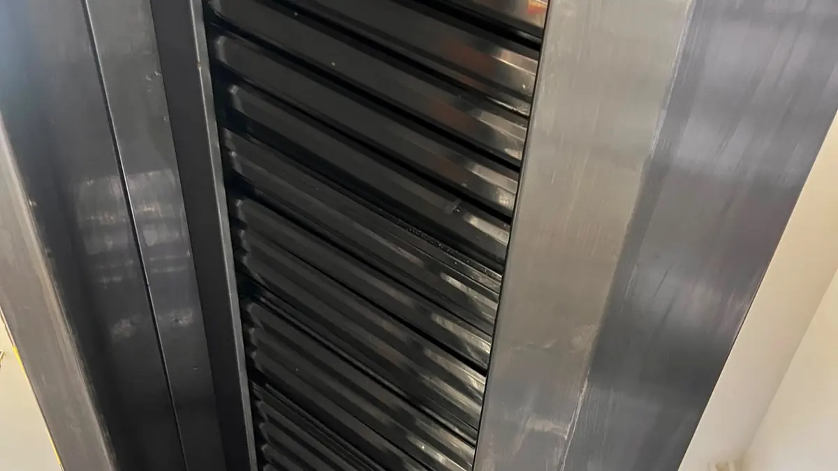 Filtre labirint curate într-o hotă din inox, văzute de jos, lângă conducta de gaz galbenă