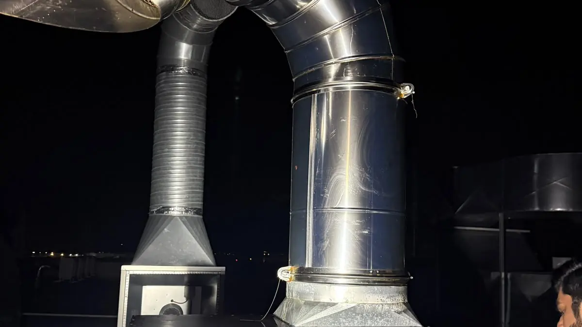 Ventilator de exhaustare pe acoperiș, racordat la tubulatură din inox, curățat noaptea de doi tehnicieni