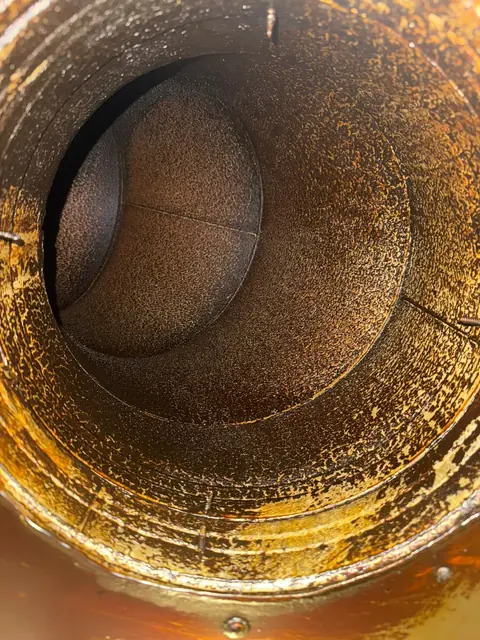 Tubulatură circulară cu reducții acoperită integral de grăsime maro-portocalie, înainte de curățare