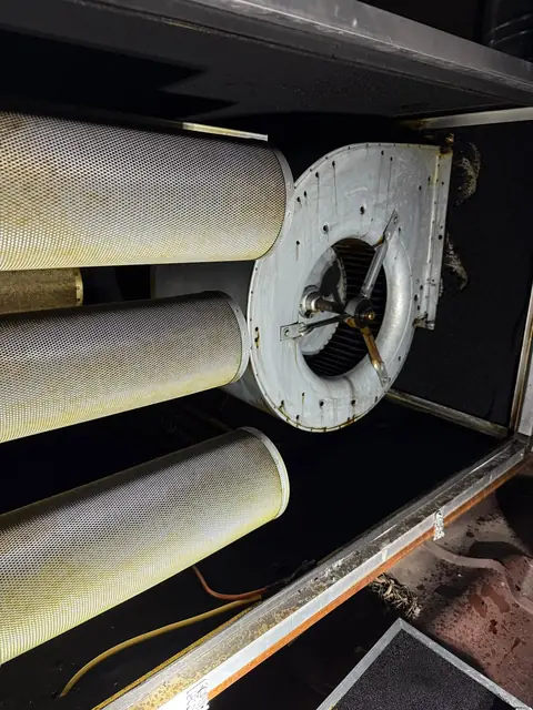 Unitate de filtrare cu trei cartușe cilindrice după curățare, cu carcasa ventilatorului degresată și argintie