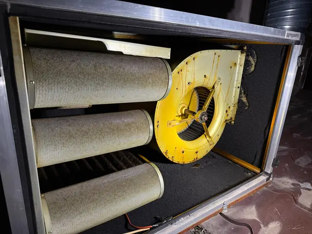 Unitate de filtrare cu trei cartușe cilindrice și ventilator cu carcasa îngălbenită de grăsime, înainte de curățare